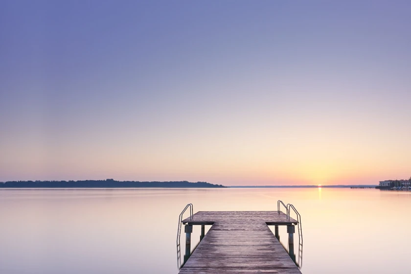 Empty dock with a vast sea and sunset sky