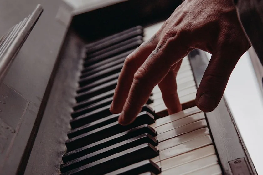 Hand playing a note on a piano